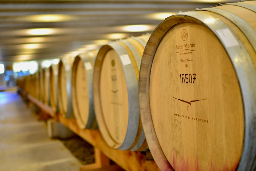 a row of wine barrels lined up in a winery