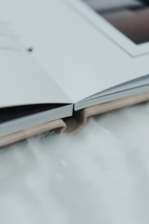 an open book sitting on top of a white table