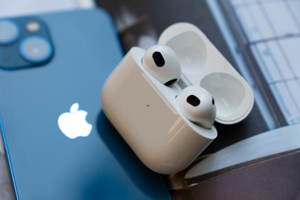 a pair of ear buds sitting on top of an iphone
