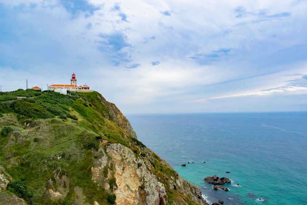 a lighthouse on a cliff overlooking the ocean