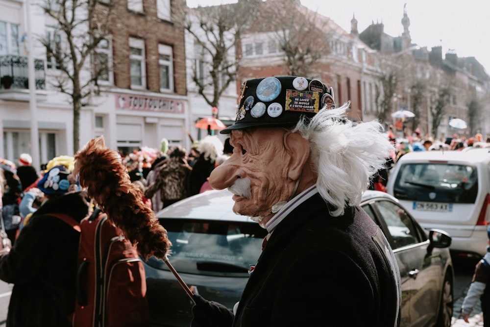 an old man with a weird hat on a crowded street