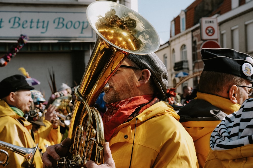 a group of men in yellow jackets playing brass instruments