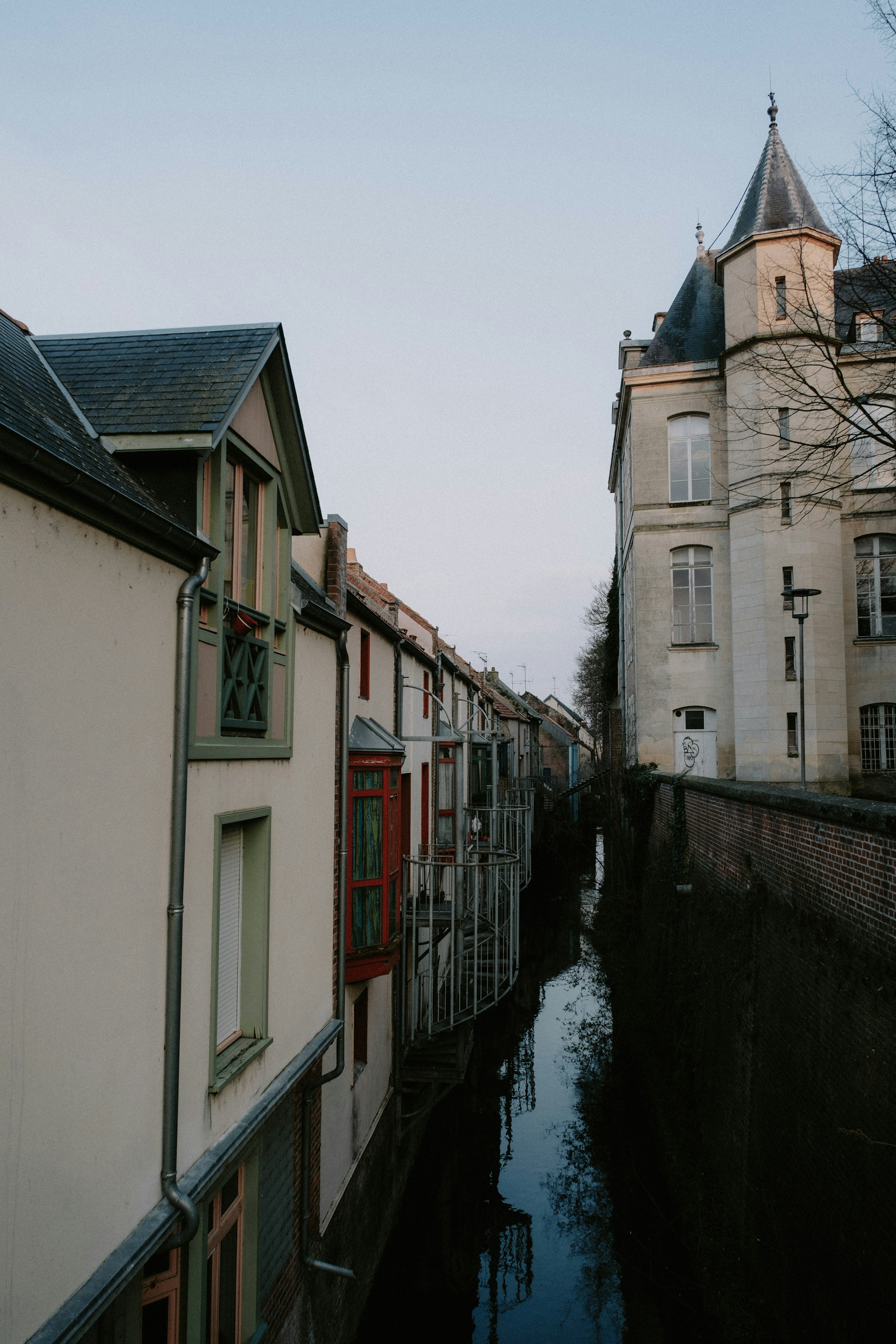 a river running through a city next to a tall building