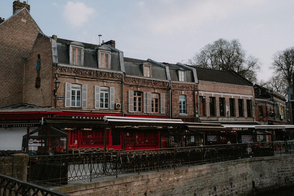 a building with a red awning next to a river