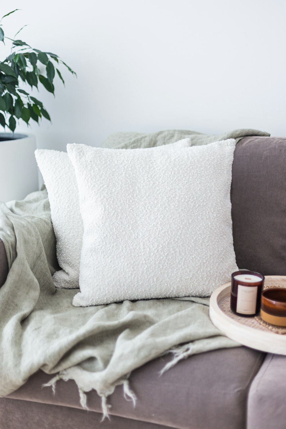 a couch with a blanket and two candles on it