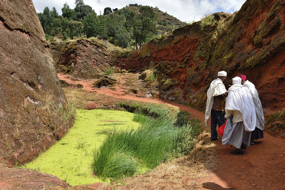 a couple of people walking down a dirt road