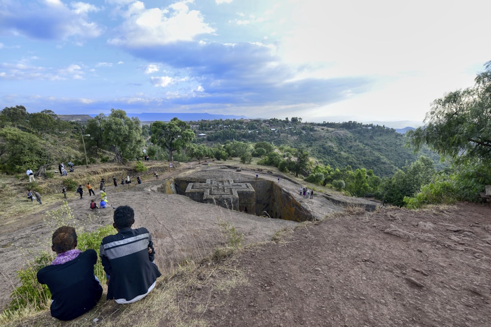 a couple of people sitting on top of a hill