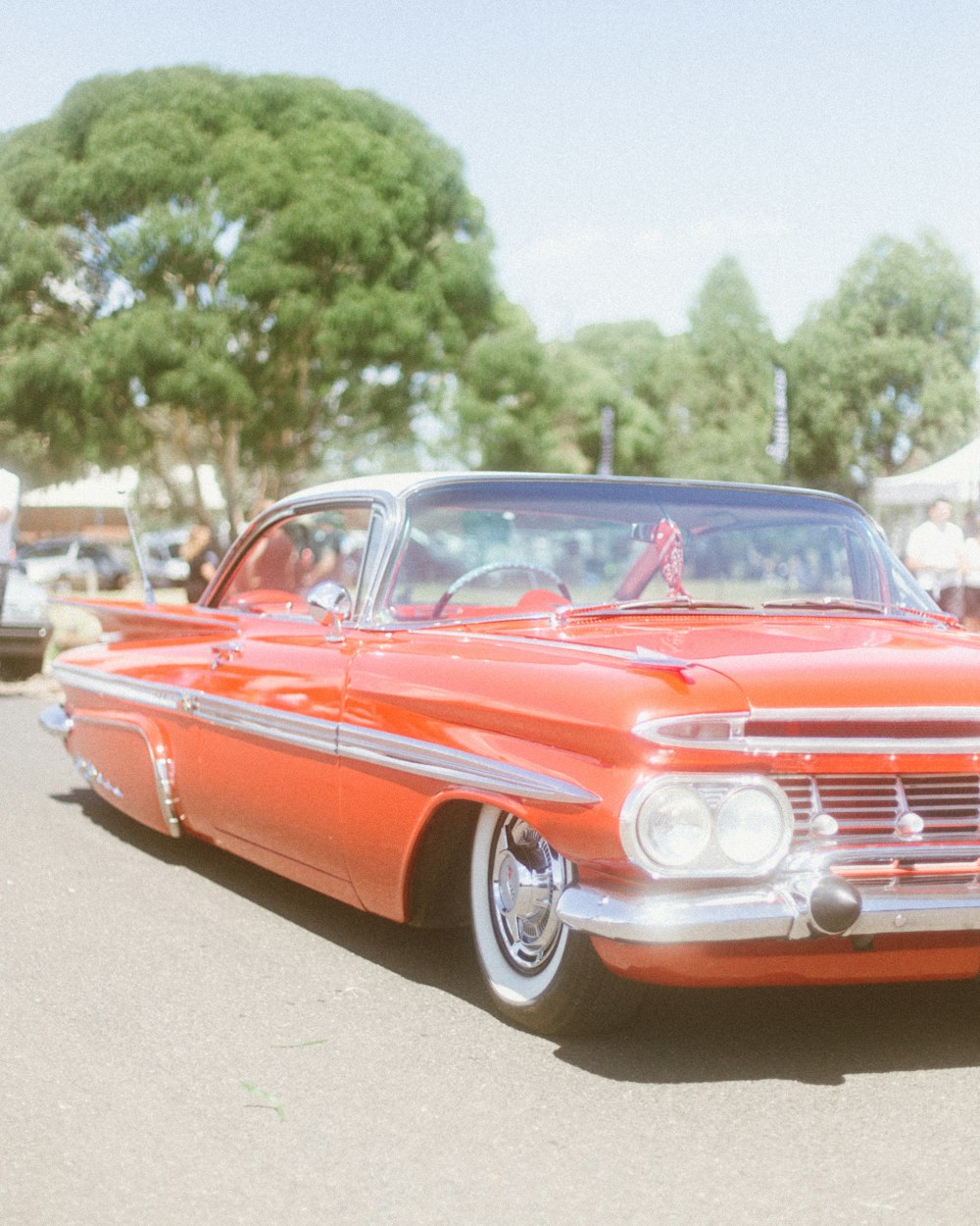 an orange classic car parked in a parking lot