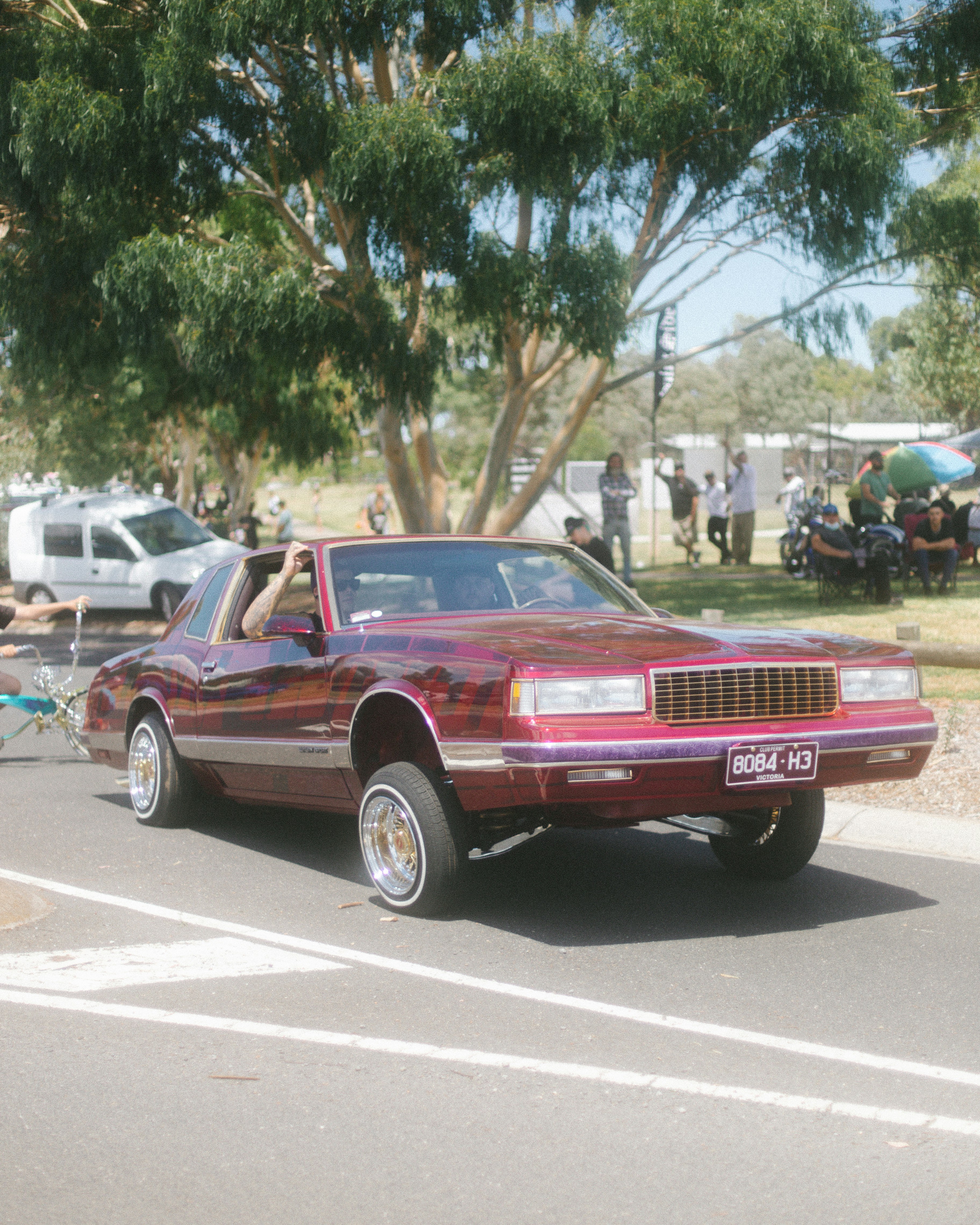a maroon car parked on the side of the road