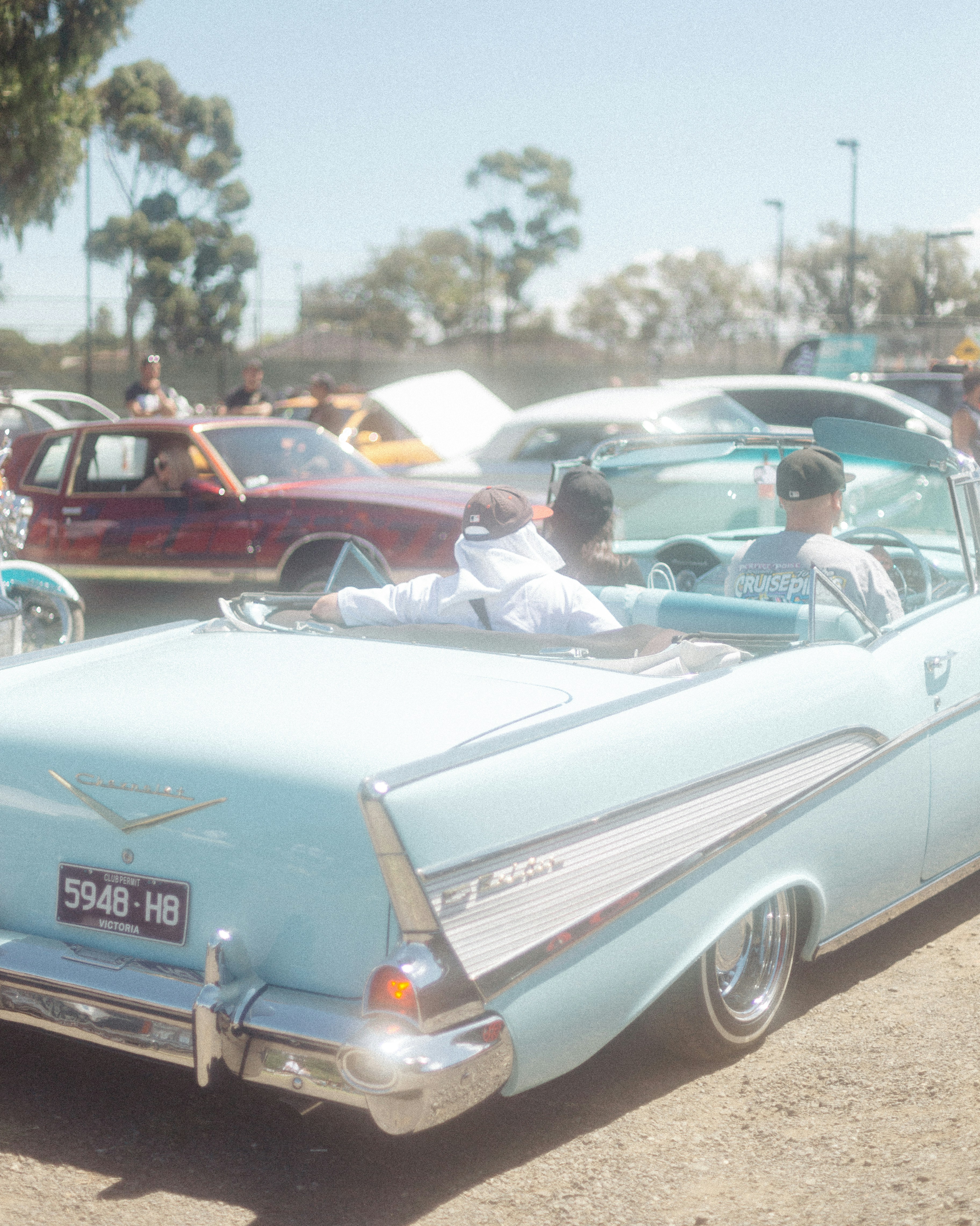 a group of people riding in the back of a blue car