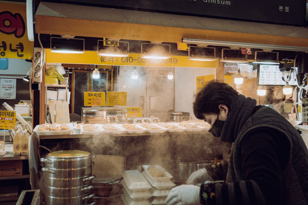 a man cooking food inside of a kitchen