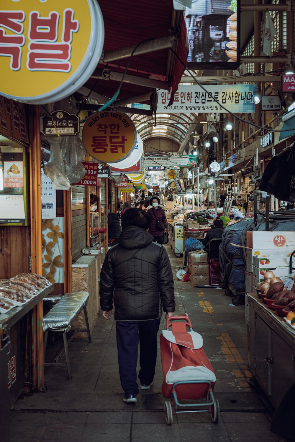 a man walking down a street next to a market