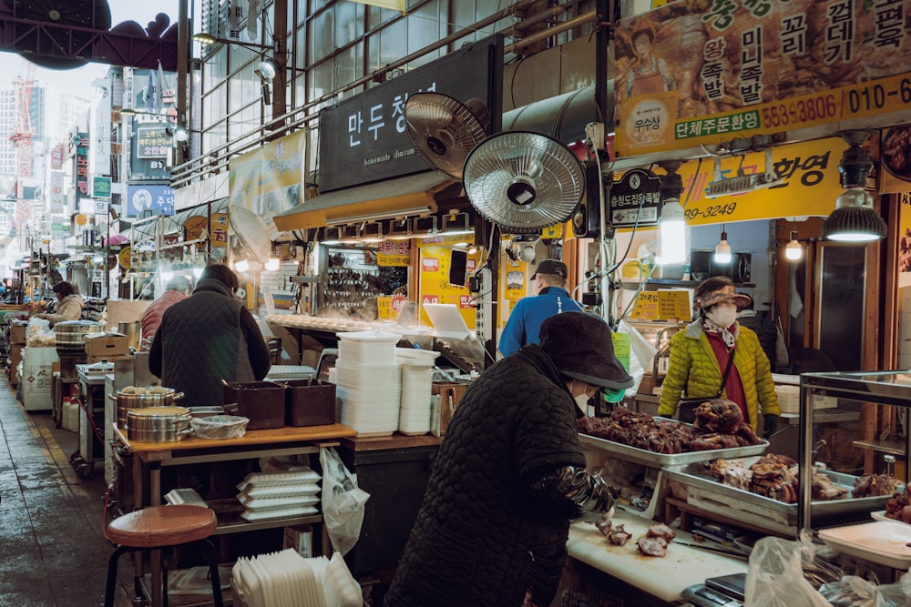 a group of people standing around a food stand