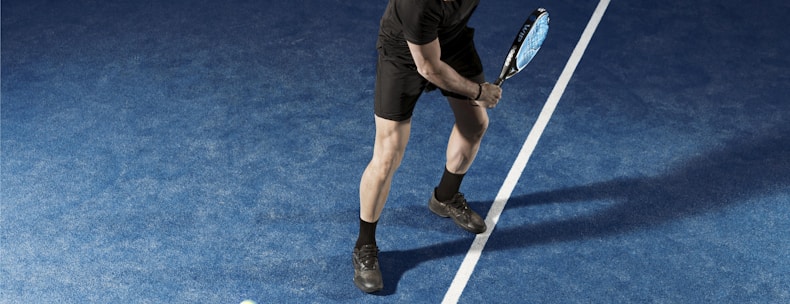 a man holding a tennis racquet on a tennis court