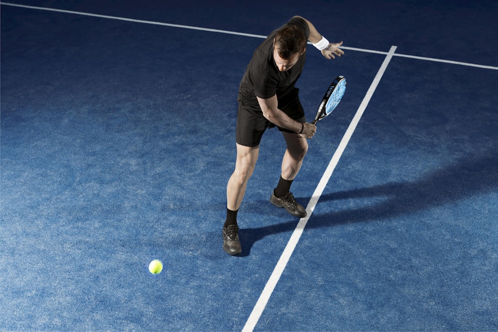 a man holding a tennis racquet on a tennis court