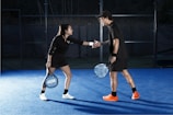 a man and woman shaking hands on a tennis court