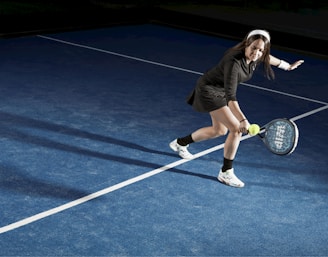 a young woman holding a tennis racquet on a tennis court