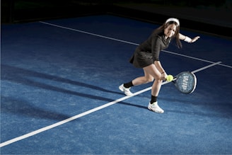 a young woman holding a tennis racquet on a tennis court