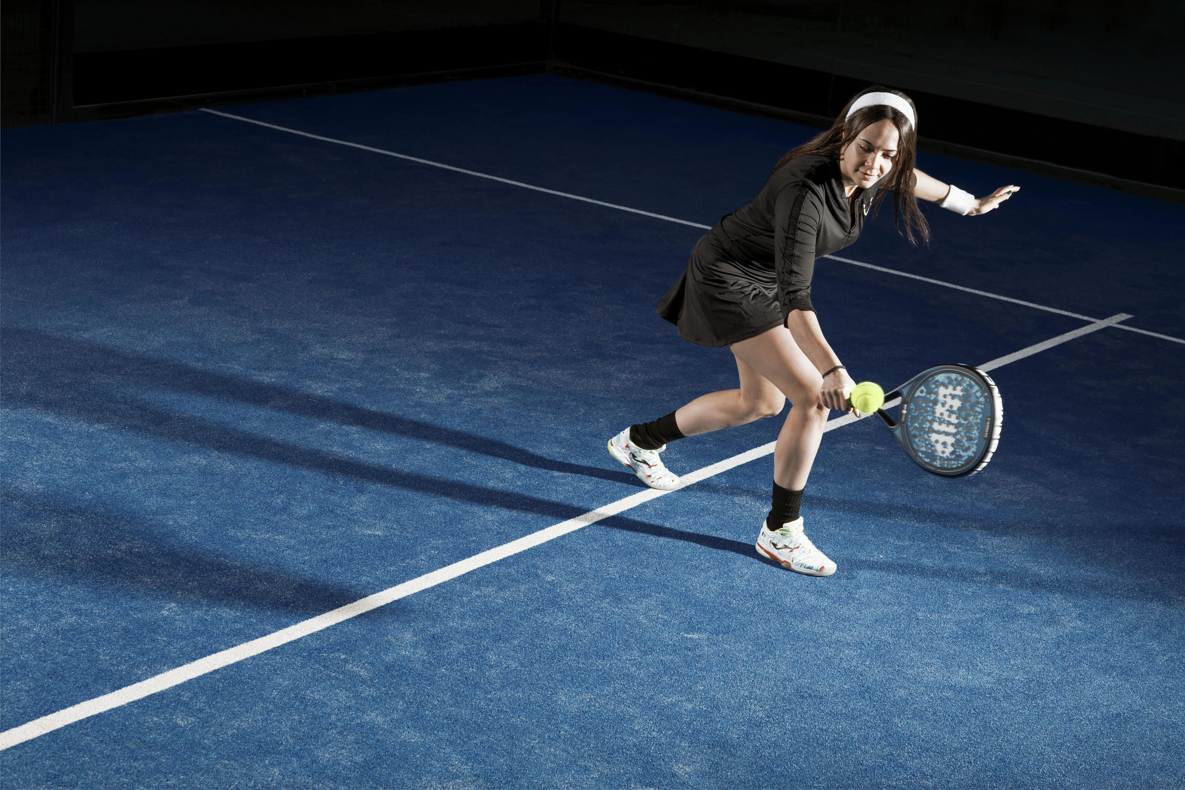 A padel player lining up a forehand on a blue court