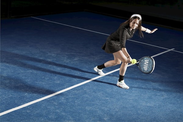 Woman playing padel on blue court