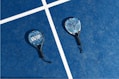 two tennis rackets laying on a tennis court