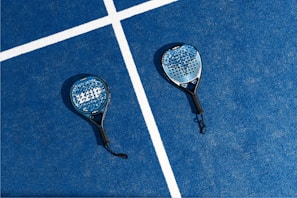 two tennis rackets laying on a tennis court