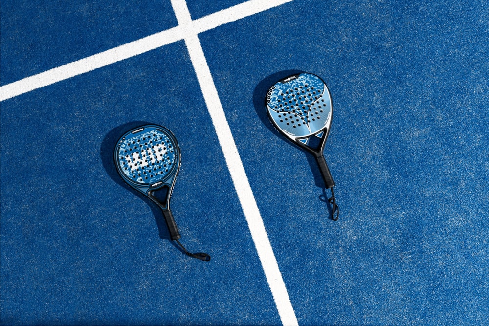 two tennis rackets laying on a tennis court