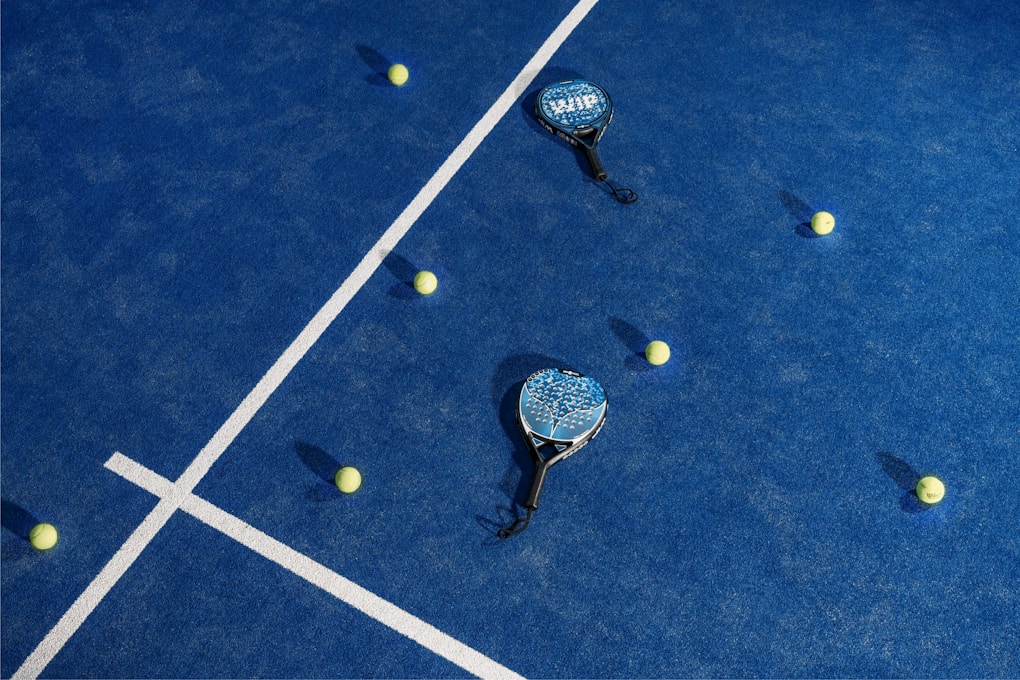 two tennis rackets and balls on a blue tennis court