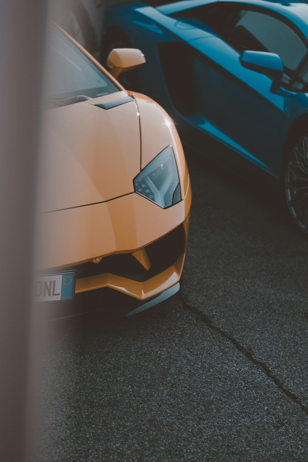 a blue and orange sports car parked next to each other