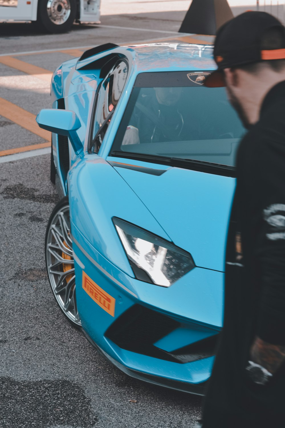 a man standing next to a blue sports car