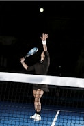 a tennis player reaching up to hit a ball