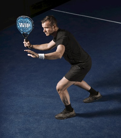 a man holding a tennis racquet on a tennis court