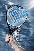 a person holding a tennis racket in the water