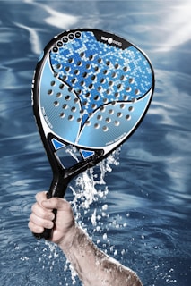 a person holding a tennis racket in the water