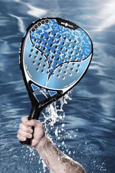 a person holding a tennis racket in the water