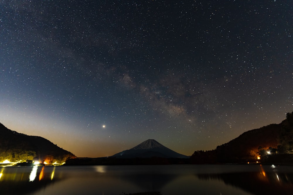 the night sky with a mountain in the background