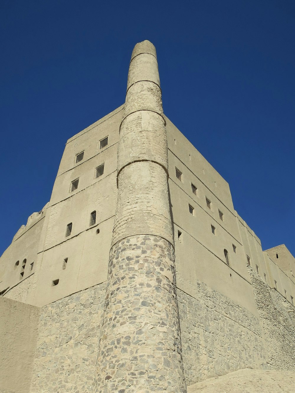 a very tall brick building with a clock on it's side