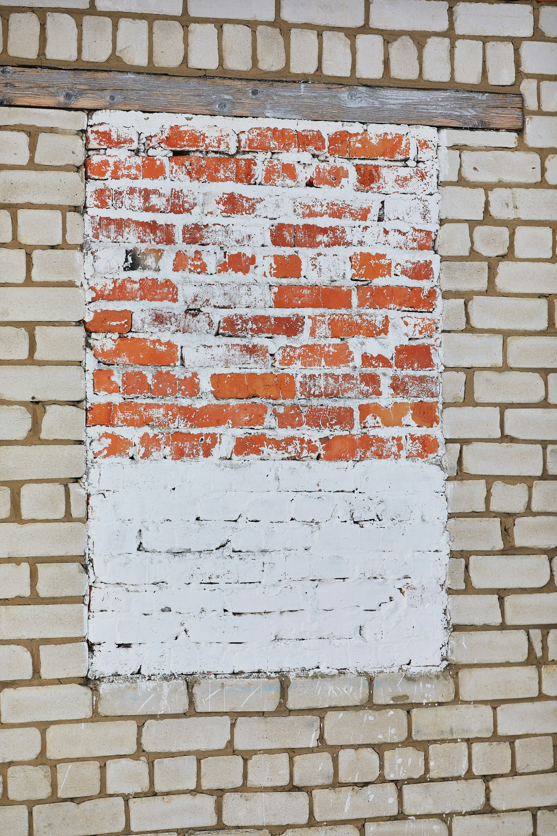 a red and white brick wall with a window