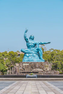 a statue of a man sitting on top of a rock
