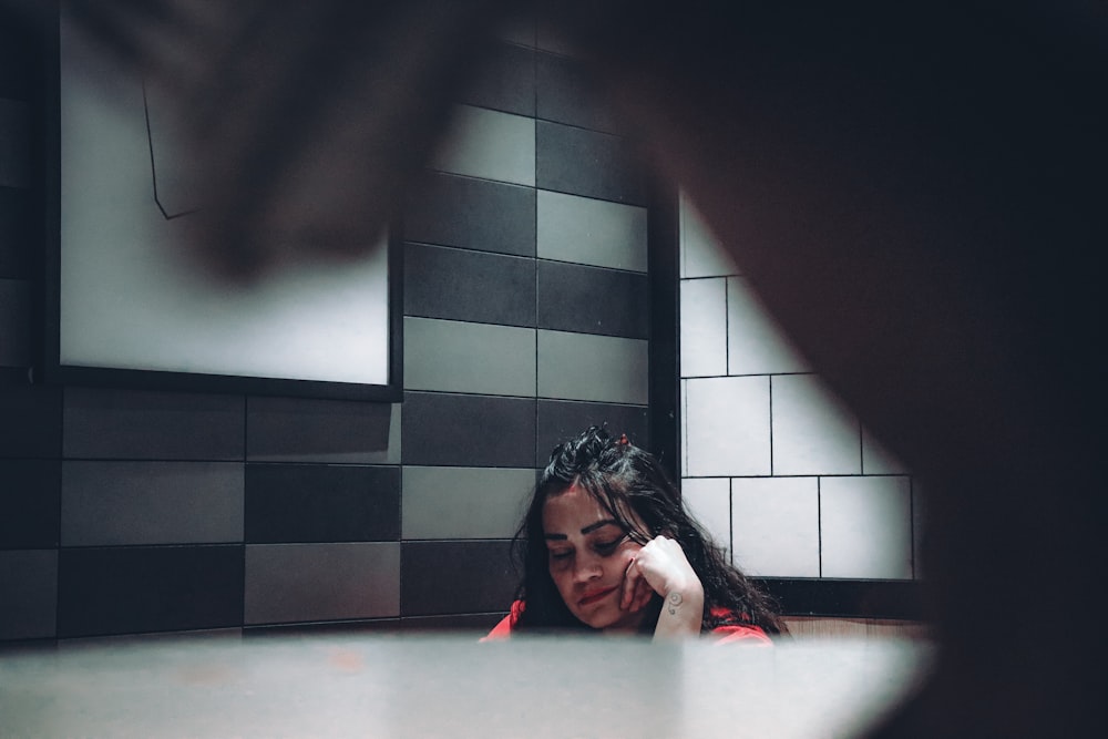 a woman sitting on the floor with her head in her hands