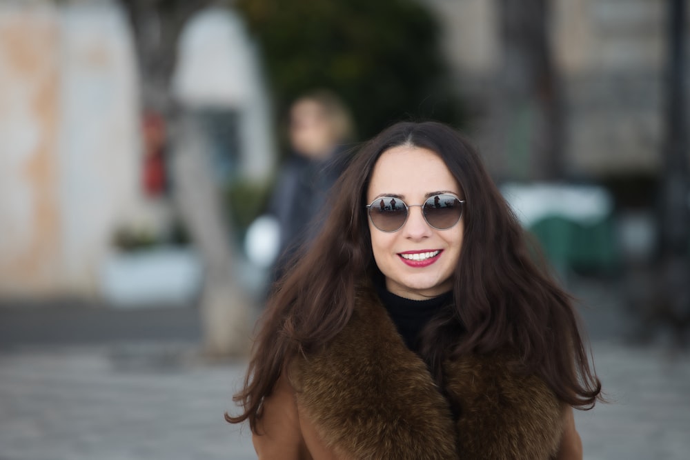 a woman wearing sunglasses and a fur vest