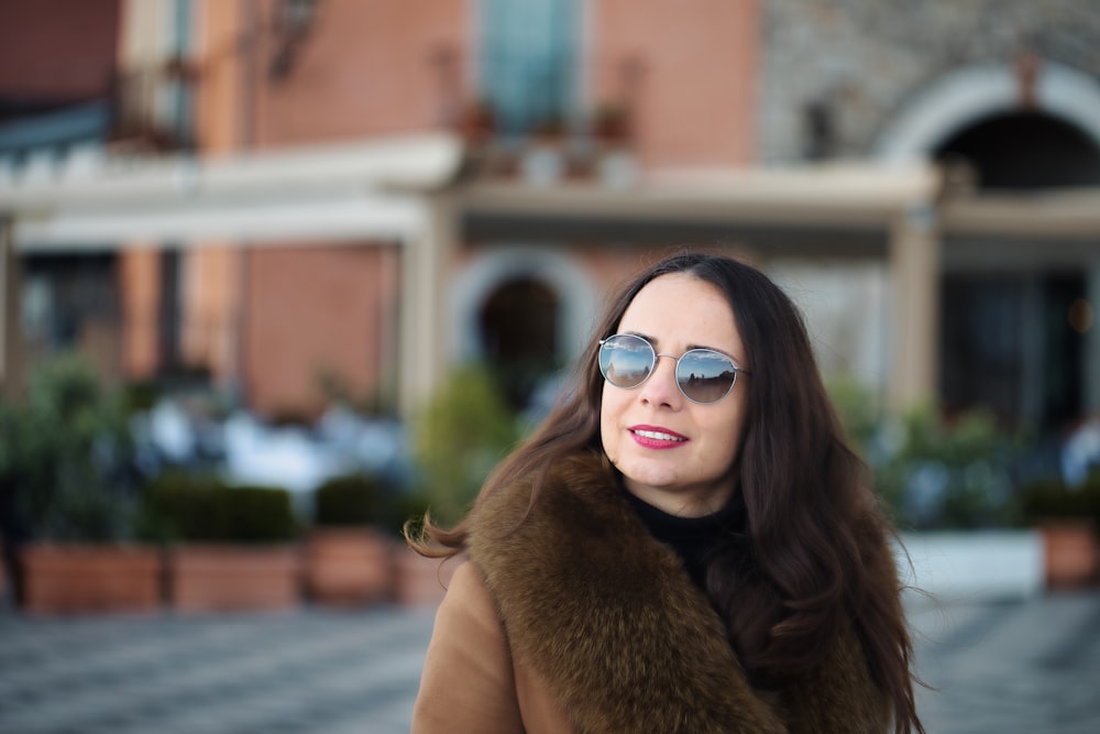 a woman wearing sunglasses and a fur coat