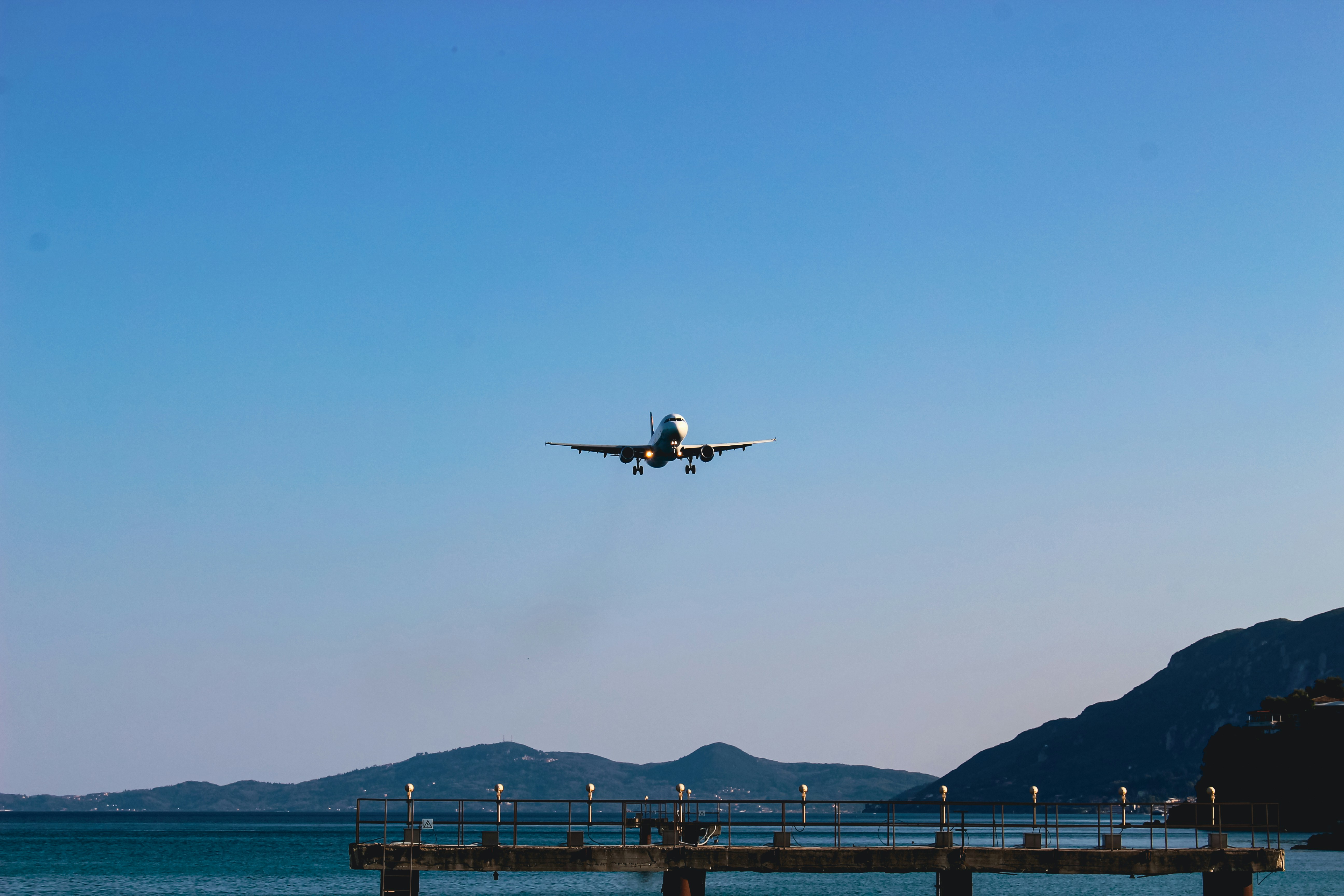 a large jetliner flying over a large body of water