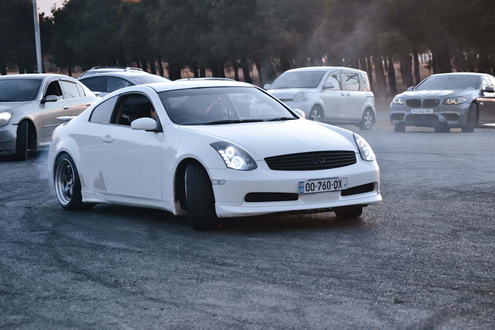 a white car parked in a parking lot next to other cars