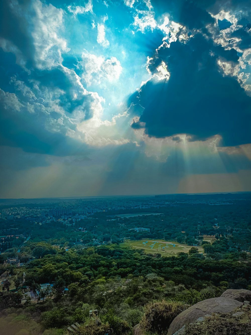 the sun shines through the clouds over a lush green valley