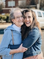 two women hugging each other in a parking lot