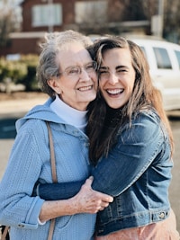 two women hugging each other in a parking lot