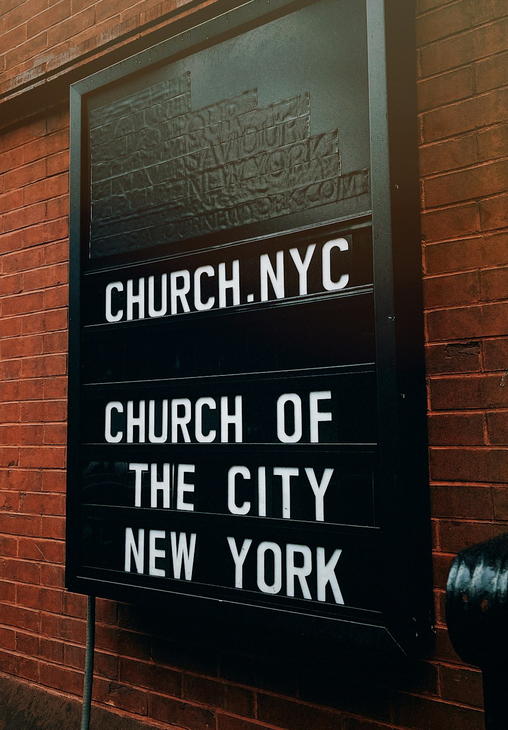 a church of the city new york sign on a brick wall