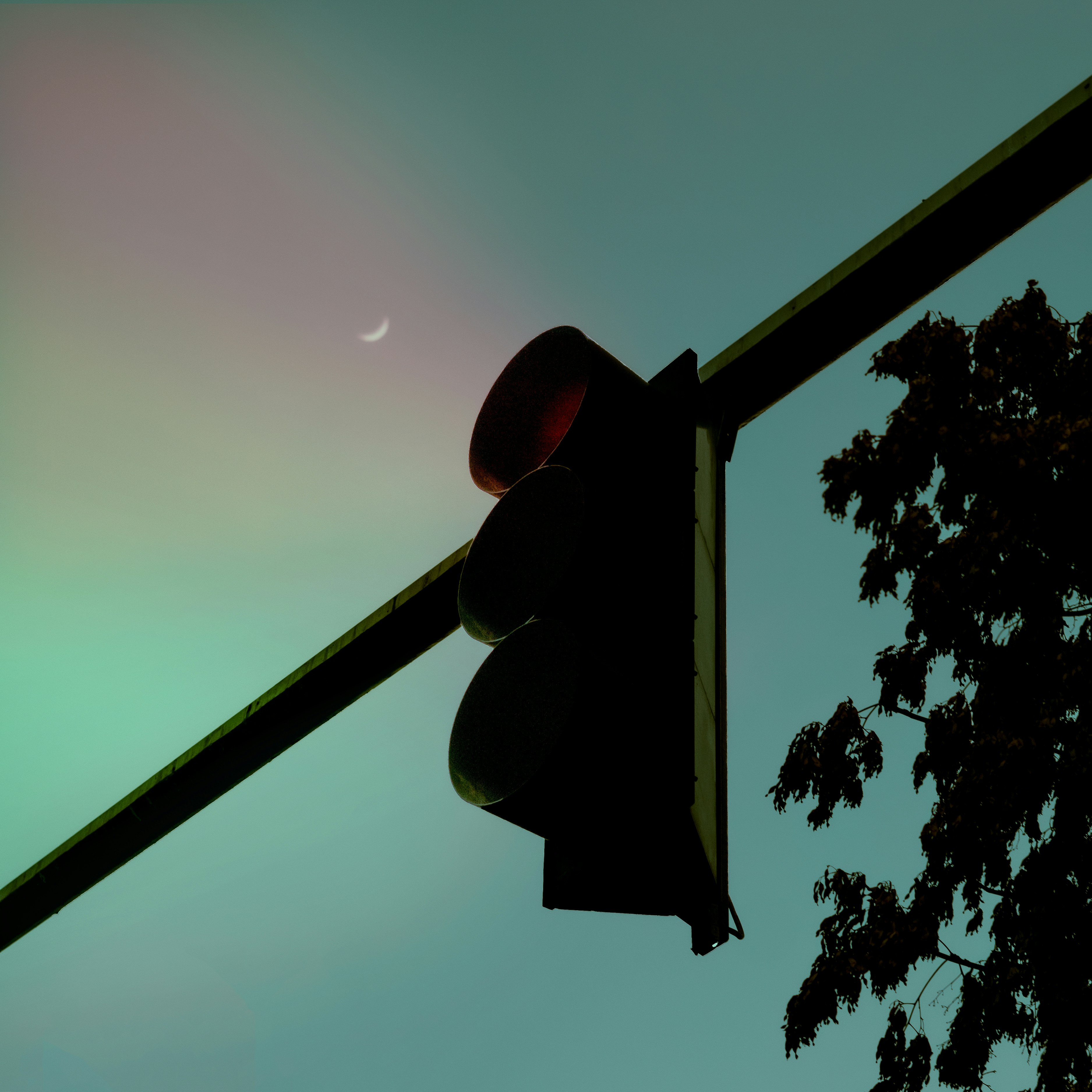 a traffic light with the moon in the background