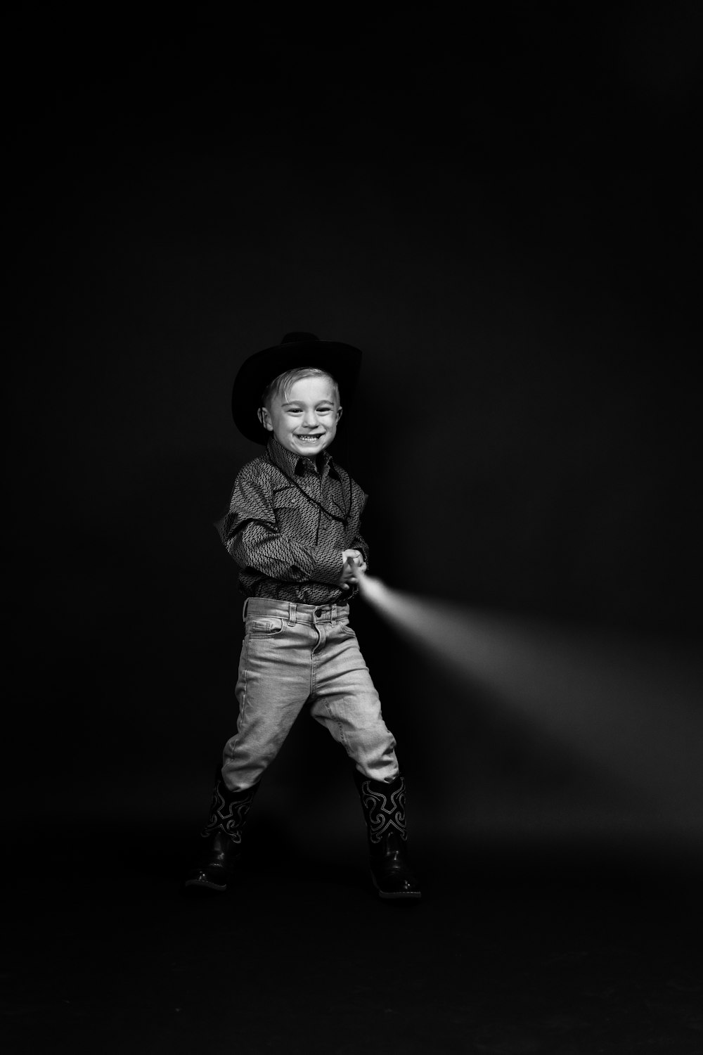 a little boy that is standing in the dark